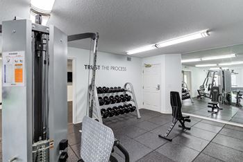 a gym with weights and cardio equipment and a sign that says trust the process at Cityscape, St Louis Park, 55416